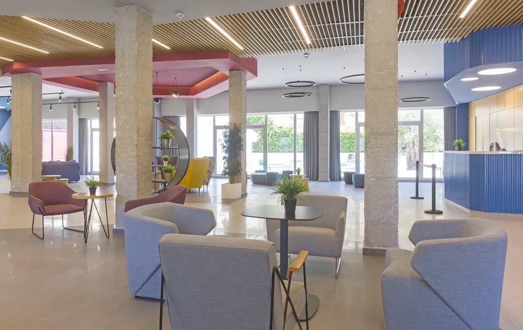 Nuevo hall de la residencia con butacas, zonas de estar y luz natural