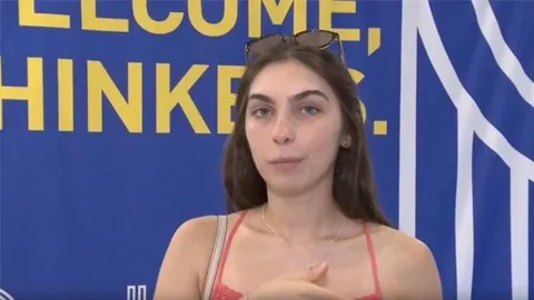 Ana habla ante el fondo azul «Welcome, Thinkers» de la RUT. Pulsa para ver su testimonio