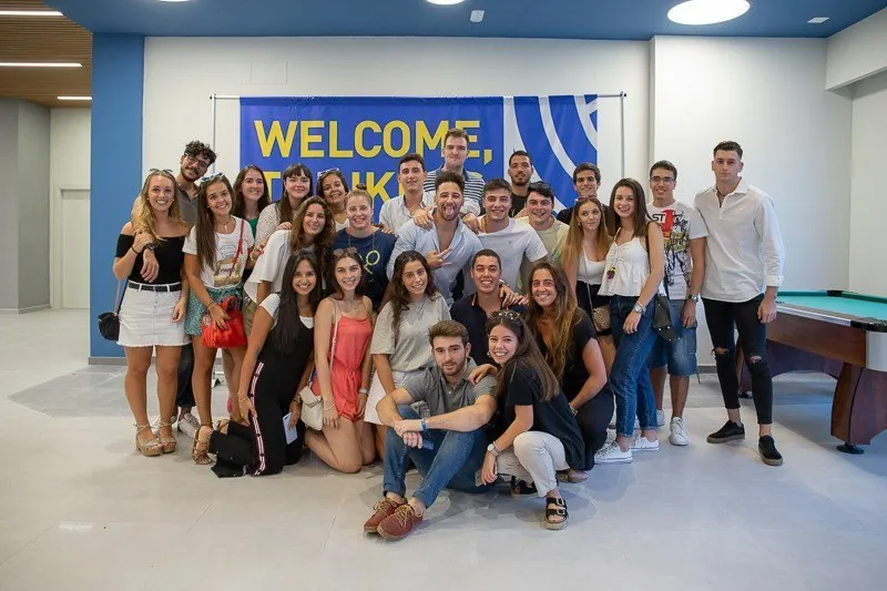 Grupo de residentes de la RUT posando junto al cartel de bienvenida en el hall